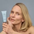 Mujer rubia mostrando la crema de día